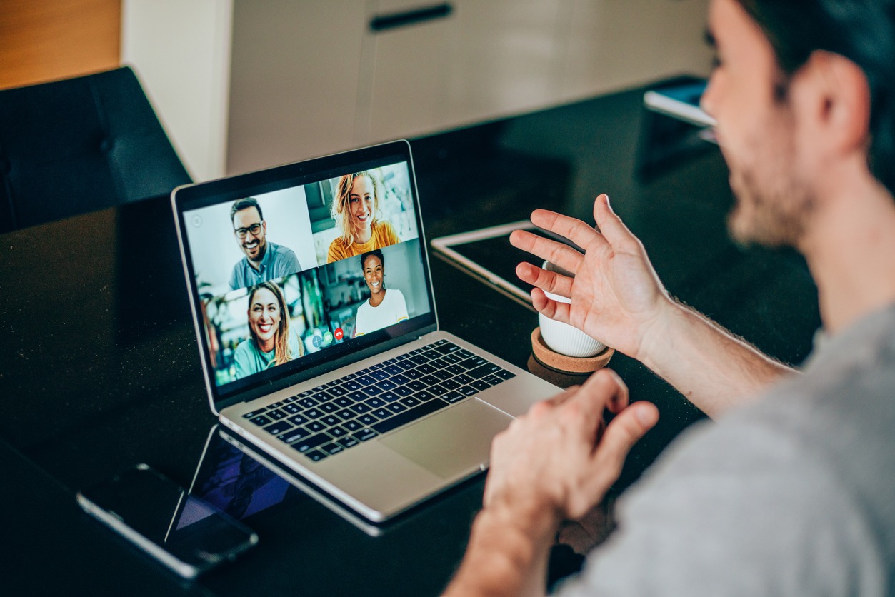 Mann vor Notebook bei Videokonferenz mit 4 Personen
